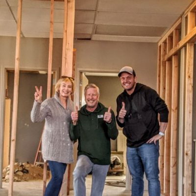Adults posing for the camera, one female and two males