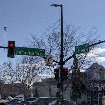 street intersection showing stop lights and street signs
