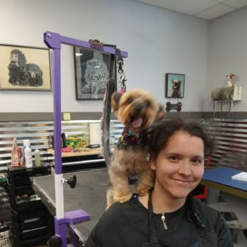 Apprentice smiling at a camera with a dog in the background